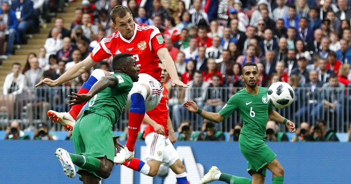 Russia's Artyom Dzyuba, centre, heads the ball and scores his sides 3rd goal of the game during the group A match between Russia and Saudi Arabia which opens the 2018 soccer World Cup at the Luzhniki stadium in Moscow, Russia, Thursday, June 14, 2018. (AP Photo/Antonio Calanni)