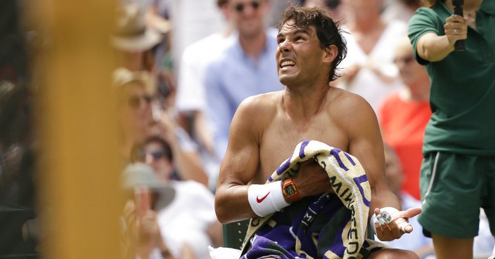 Rafael Nadal of Spain speaks to the umpire as he wipes himself with a towel after the first set of his men's singles match against Mikhail Kukushkin of Kazakhstan, on the fourth day of the Wimbledon Tennis Championships in London, Thursday July 5, 2018. (AP Photo/Tim Ireland)