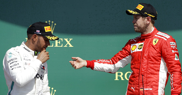 Ferrari driver Sebastian Vettel of Germany, right, speaks with second placed Mercedes driver Lewis Hamilton of Britain after winning the British Formula One Grand Prix at the Silverstone racetrack, Silverstone, England, Sunday, July 8, 2018. (AP Photo/Luca Bruno)