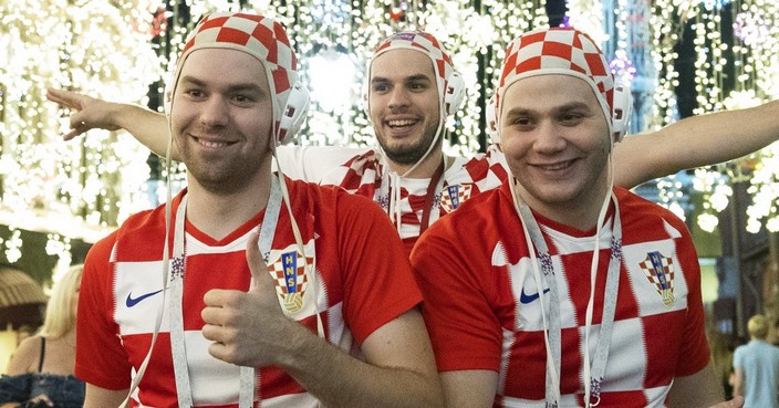 Croatia's soccer fans celebrate in Nikolskaya street near the Kremlin as their team won the semifinal soccer match between Croatia and England during the 2018 soccer World Cup at the Luzhniki stadium in Moscow, Russia, early Thursday, July 12, 2018. The St. Basil's Cathedral is left in the background. (AP Photo/Pavel Golovkin)