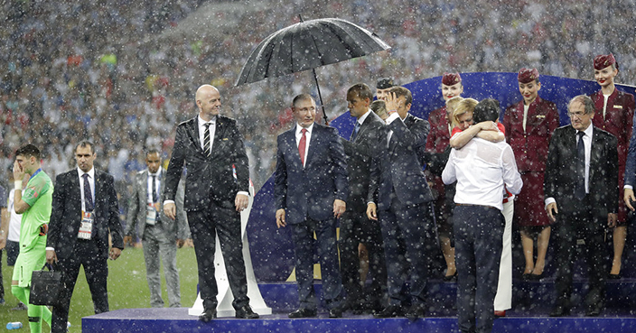 FIFA President Gianni Infantino, third left, gestures as Russian President Vladimir Putin stands underneath an umbrella as Croatian President Kolinda Grabar-Kitarovic greets Croatia head coach Zlatko Dalic after the final match between France and Croatia at the 2018 soccer World Cup in the Luzhniki Stadium in Moscow, Russia, Sunday, July 15, 2018. France won the final 4-2. (AP Photo/Matthias Schrader)