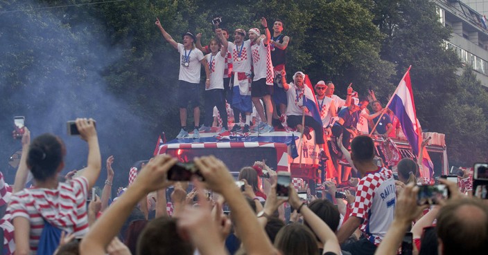 Croatia's national soccer team members are seen on top of an open bus as they are greeted by fans during a celebration in central Zagreb, Croatia, Monday, July 16, 2018. In an outburst of national pride and joy, Croatia rolled out a red carpet and staged a euphoric heroes' welcome for the national team on Monday despite its loss to France in the World Cup final. (AP Photo/Marko Drobnjakovic)