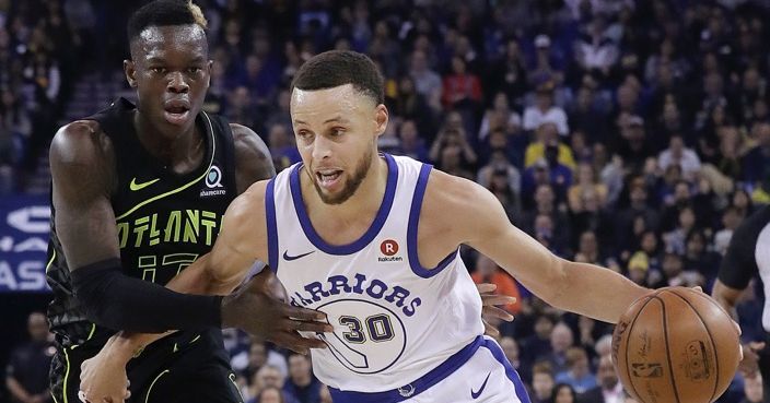 Golden State Warriors guard Stephen Curry (30) dribbles against Atlanta Hawks guard Dennis Schroder during the first half of an NBA basketball game in Oakland, Calif., Friday, March 23, 2018. (AP Photo/Jeff Chiu)