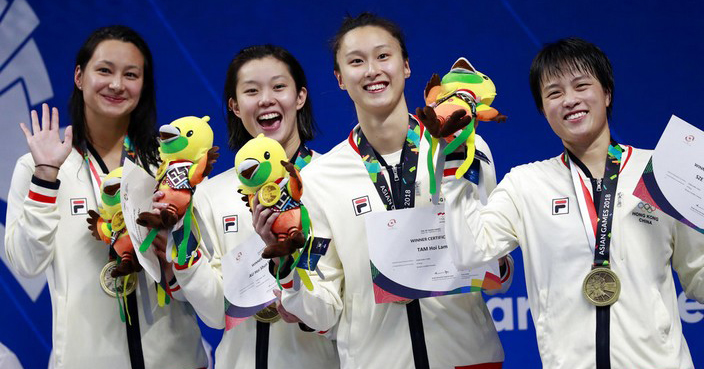 The Hong Kong women's 4x100m freestyle relay team celebrate on the podium with their bronze medals during the swimming competition at the 18th Asian Games in Jakarta, Indonesia, Sunday, Aug. 19, 2018. (AP Photo/Bernat Armangue)