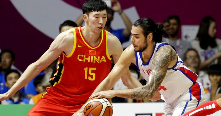 Philippines' Christian Standhardinger, centre, attempts to take the ball past China's Qi Zhou, left, and Rui Zhao, right, during their men's basketball game at the 18th Asian Games in Jakarta, Indonesia on Tuesday, Aug. 21, 2018. (AP Photo/Aaron Favila)