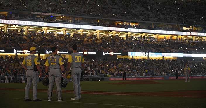 LOS ANGELES, CA - AUGUST 25: San Diego Padres players stand on the field in the 12th inning when the Los Angeles Dodgers were at bat and the power went out at Dodger Stadium on August 25, 2018 in Los Angeles, California. All players across MLB will wear nicknames on their backs as well as colorful, non-traditional uniforms featuring alternate designs inspired by youth-league uniforms during Players Weekend. (Photo by John McCoy/Getty Images)