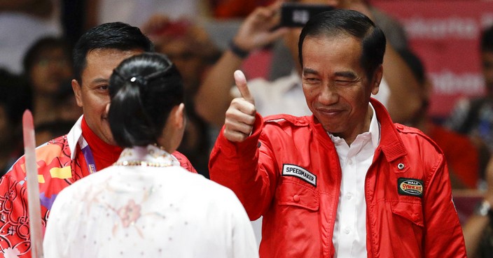 FILE - In this Aug. 20, 2018, file photo, Indonesian President Joko Widodo, right, gestures to Indonesia's Lindswell Lindswell after her performance at the Wushu women's Taijijian event at the 18th Asian Games in Jakarta, Indonesia. Indonesia's hosting of the Asian Games and a record haul of gold medals has swelled national pride, providing a boost to the re-election campaign of President Joko 