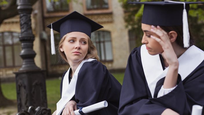 Sad after graduation. Two beautiful friends feeling very sad after graduation from favorite university