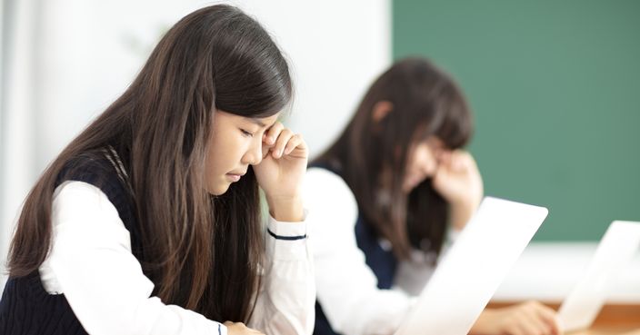 tired teenagers student studying with laptop in classroom