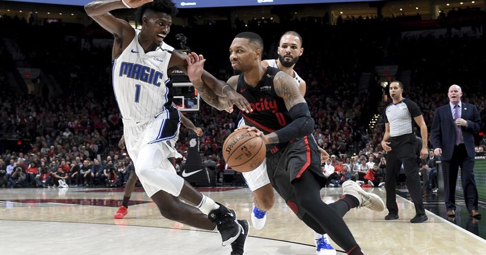 Portland Trail Blazers guard Damian Lillard, right, drives to the basket on Orlando Magic forward Jonathan Isaac, left, during the second half of an NBA basketball game in Portland, Ore., Wednesday, Nov. 28, 2018. The Blazers won 115-112. (AP Photo/Steve Dykes)