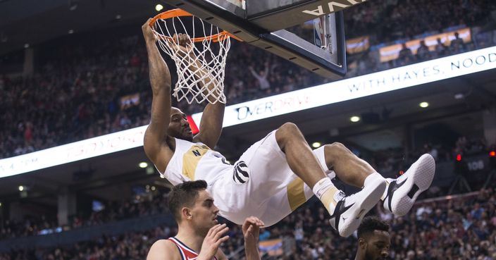 Toronto Raptors forward Kawhi Leonard hangs from the basket after scoring on the Washington Wizards during the first half of an NBA basketball game Friday, Nov. 23, 2018, in Toronto. (Chris Young/The Canadian Press via AP)