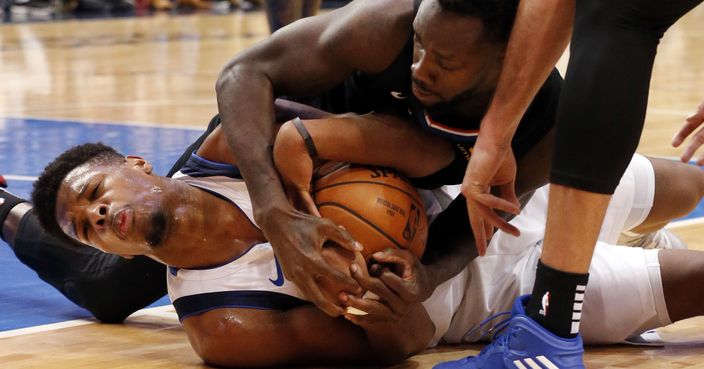 Dallas Mavericks guard Dennis Smith Jr. (1) fights for the ball with Los Angeles Clippers guard Patrick Beverley (21) during the second half of an NBA basketball game in Dallas, Sunday, Dec. 2, 2018. Smith Jr. lost a tooth on the play. Dallas won 114-110. (AP Photo/Michael Ainsworth)
