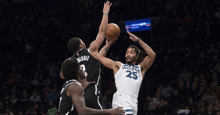 Minnesota Timberwolves guard Derrick Rose, right, passes the ball around Brooklyn Nets forward Ed Davis, left, and guard Spencer Dinwiddie, center, during the first half of an NBA basketball game, Friday, Nov. 23, 2018, in New York. (AP Photo/Mary Altaffer)