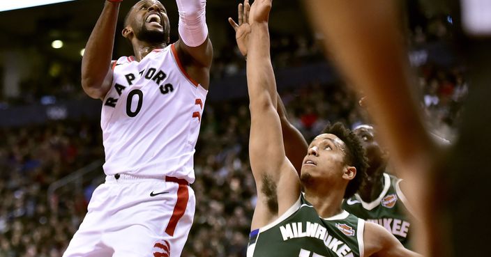 Toronto Raptors forward CJ Miles (0) drives to the net as Milwaukee Bucks guard Malcolm Brogdon (13) and teammates attempt to block during second-half NBA basketball game action in Toronto, Sunday, Dec. 9, 2018. (Frank Gunn/The Canadian Press via AP)