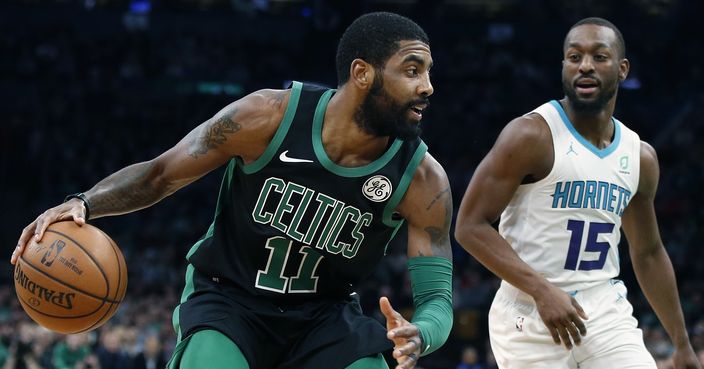 Boston Celtics' Kyrie Irving (11) drives for the basket against Charlotte Hornets' Kemba Walker (15) during the first half of an NBA basketball game in Boston, Sunday, Dec. 23, 2018. (AP Photo/Michael Dwyer)