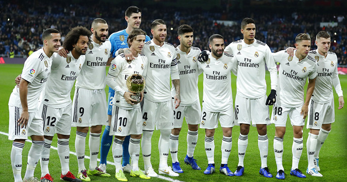 Real Madrid's Luka Modric holds his Ballon d'Or (Golden Ball) award as European Footballer of the Year as he poses with his teammates prior of he Spanish La Liga soccer match between Real Madrid and Rayo Vallecano at the Bernabeu stadium in Madrid, Spain, Saturday, Dec. 15, 2018. (AP Photo/Manu Fernandez)