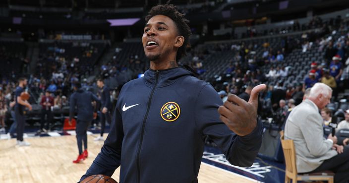 Denver Nuggets guard Nick Young jokes with members of the Dallas Mavericks before the first half of an NBA basketball game Tuesday, Dec. 18, 2018, in Denver. (AP Photo/David Zalubowski)