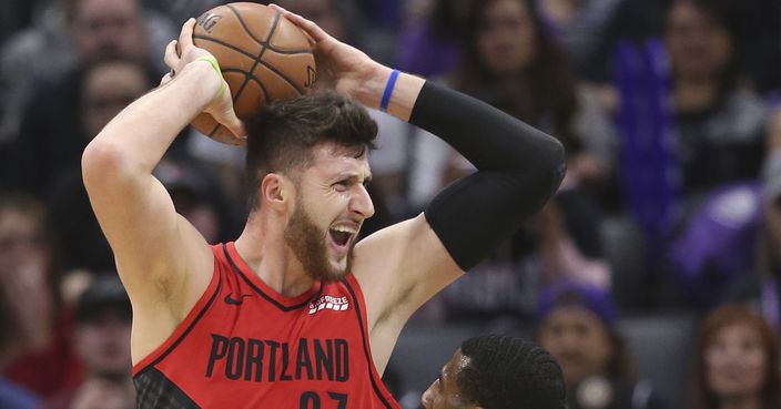 Portland Trail Blazers center Jusuf Nurkic looks to pass the ball over Sacramento Kings guard Iman Shumpert during the first half of an NBA basketball game Tuesday, Jan. 1, 2019, in Sacramento, Calif. (AP Photo/Rich Pedroncelli)