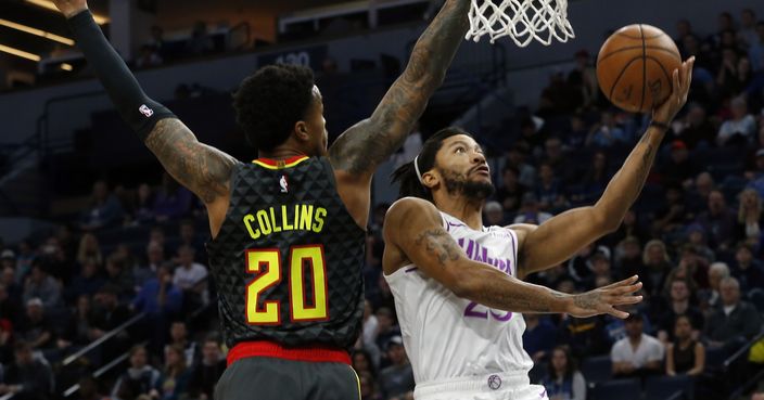 Minnesota Timberwolves' Derrick Rose, right, lays up a shot as Atlanta Hawks' John Collins defends during the first half of an NBA basketball game Friday, Dec. 28, 2018, in Minneapolis. (AP Photo/Jim Mone)