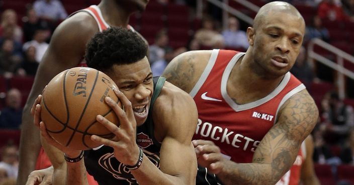 Milwaukee Bucks forward Giannis Antetokounmpo, left, protects his rebound from Houston Rockets forward PJ Tucker, right, during the first half of an NBA basketball game Wednesday, Jan. 9, 2019, in Houston. (AP Photo/Michael Wyke)