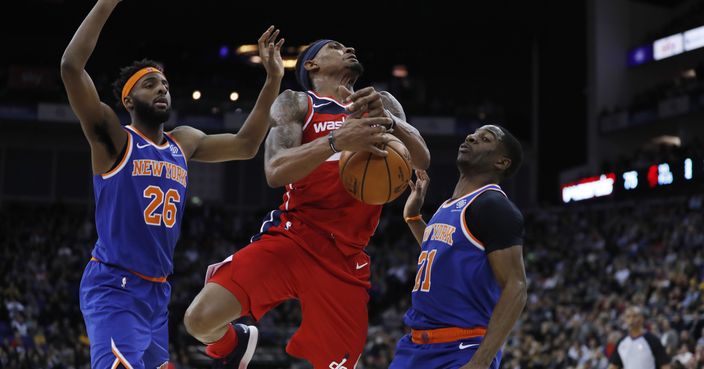 Washington Wizards guard Bradley Beal (3), is drives to the basket flanked by New York Knicks center Mitchell Robinson (26), left, and his teammate guard Damyean Dotson (21), during an NBA basketball game between New York Knicks and Washington Wizards at the O2 Arena, in London, Thursday, Jan.17, 2019. (AP Photo/Alastair Grant)
