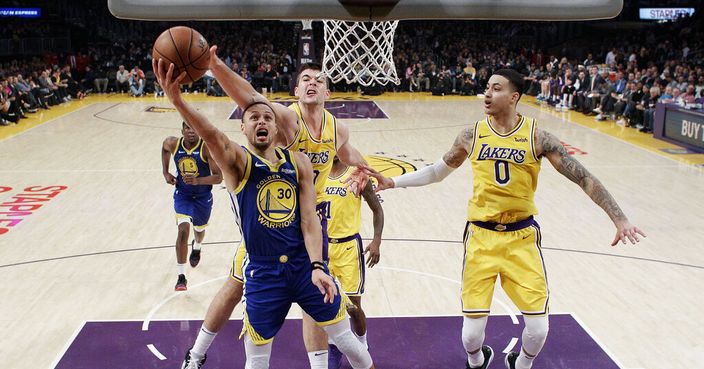 Golden State Warriors' Stephen Curry (30) drives to basket as Los Angeles Lakers' Ivica Zubac, center, and Kyle Kuzma (0) defend during the first half of an NBA basketball game, Monday, Jan. 21, 2019, in Los Angeles. (AP Photo/Marcio Jose Sanchez)