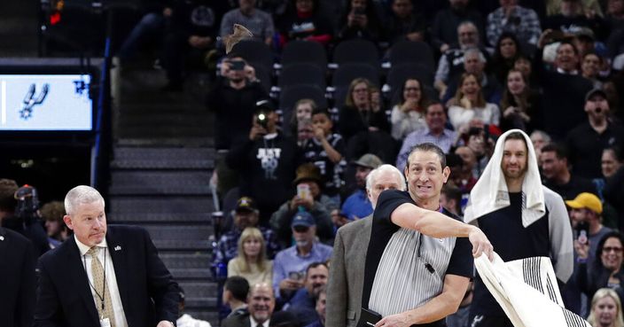 An official uses a towel to swat at a bat during the first half of an NBA basketball game between the San Antonio Spurs and the Brooklyn Nets, in San Antonio, Thursday, Jan. 31, 2019. (AP Photo/Eric Gay)
