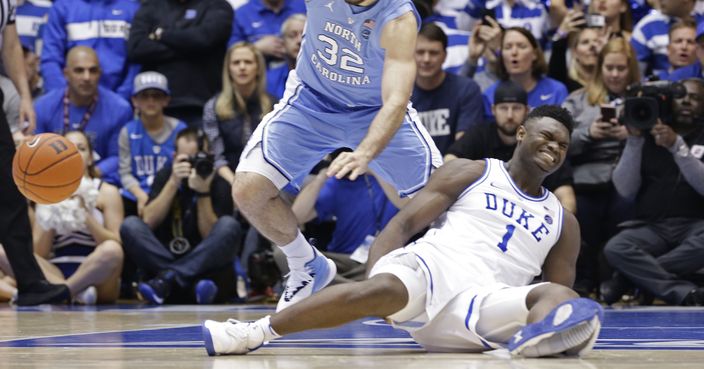 Duke's Zion Williamson (1) falls to the floor with an injury while chasing the ball with North Carolina's Luke Maye (32) during the first half of an NCAA college basketball game in Durham, N.C., Wednesday, Feb. 20, 2019. (AP Photo/Gerry Broome)