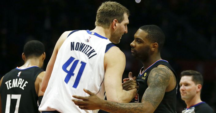 Los Angeles Clippers guard Sindarius Thornwell, second right, congratulates Dallas Mavericks forward Dirk Nowitzki, for playing in his last game against the Clippers in an NBA basketball game in Los Angeles, Monday, Feb. 25, 2019. With nine seconds to go, Clippers coach Doc Rivers grabbed the public address announcer's mic to salute Nowitzki, who received a standing ovation. He scored 12 points on 3-of-10 shooting. (AP Photo/Alex Gallardo)