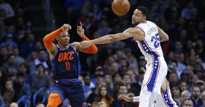 Oklahoma City Thunder guard Russell Westbrook (0) passes around Philadelphia 76ers guard Ben Simmons (25) during the first half of an NBA basketball game Thursday, Feb. 28, 2019, in Oklahoma City. (AP Photo/Sue Ogrocki)