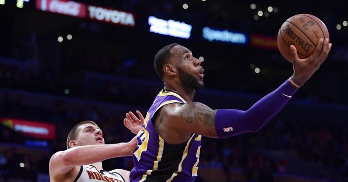 Los Angeles Lakers forward LeBron James, right, shoots as Denver Nuggets center Nikola Jokic defends during the second half of an NBA basketball game Wednesday, March 6, 2019, in Los Angeles. The Nuggets won 115-99. (AP Photo/Mark J. Terrill)
