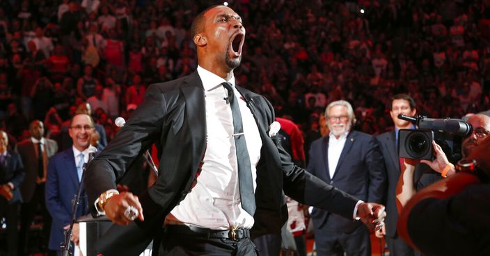 Former Miami Heat player Chris Bosh reacts at the team's retirement of his jersey at halftime of an NBA game between the Heat and the Orlando Magic, Tuesday, March 26, 2019, in Miami. At right is Heat owner Micky Arison. Bosh played 13 seasons, the first seven in Toronto and the last six in Miami. He averaged 19.2 points and 8.5 rebounds, was an All-Star 11 times and won two championships.(AP Photo/Joe Skipper)