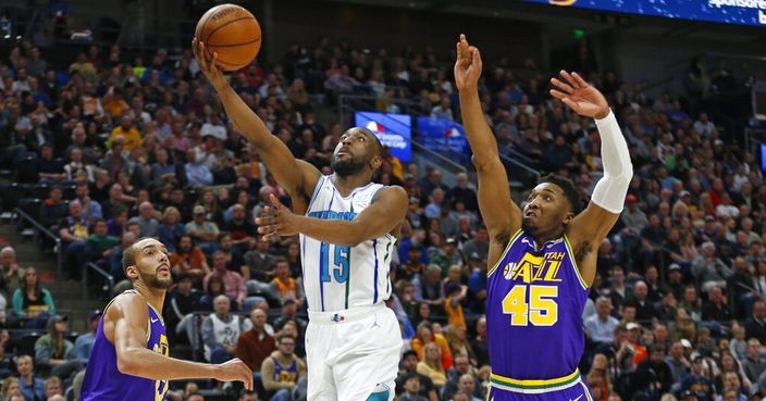 Charlotte Hornets guard Kemba Walker (15) lays up the ball as Utah Jazz's Rudy Gobert, left, and Donovan Mitchell (45) defend during the first half of an NBA basketball game, Monday, April 1, 2019, in Salt Lake City. (AP Photo/Rick Bowmer)