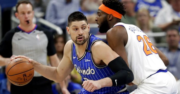 Orlando Magic's Nikola Vucevic, left, makes a move to get to the basket against New York Knicks' Mitchell Robinson during the first half of an NBA basketball game Wednesday, April 3, 2019, in Orlando, Fla. (AP Photo/John Raoux)