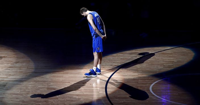 Dallas Mavericks forward Dirk Nowitzki stands on the court listening as former players pay tribute to him after the team's NBA basketball game against the Phoenix Suns in Dallas, Tuesday, April 9, 2019. (AP Photo/Tony Gutierrez)