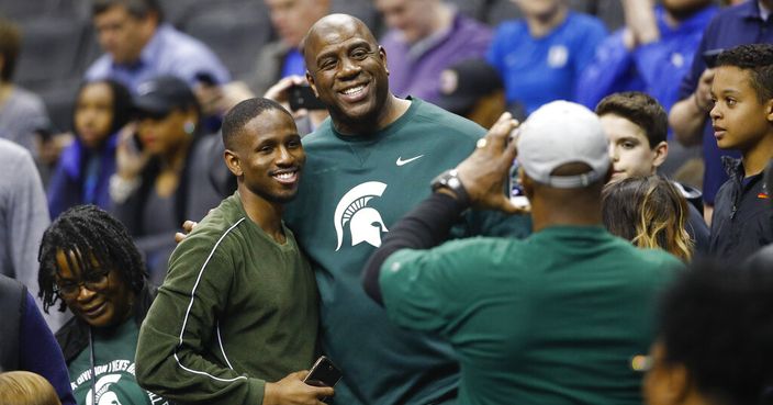 Los Angeles Lakers president and Michigan State alumni Magic Johnson, center, poses for photos before the start of a NCAA men's East Regional final college basketball game between Michigan State and Duke in Washington, Sunday, March 31, 2019. (AP Photo/Patrick Semansky)