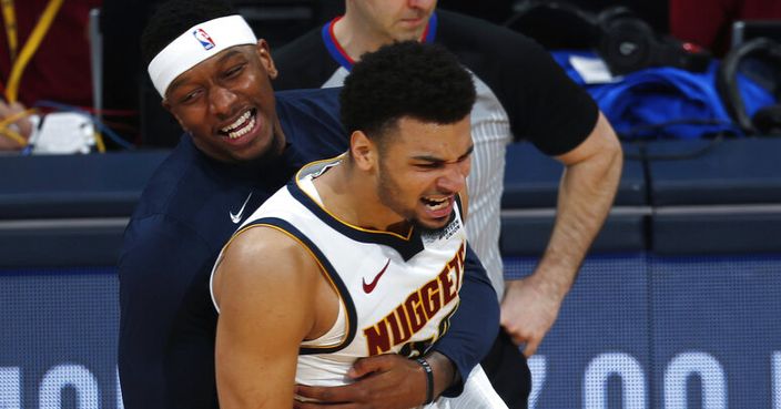Denver Nuggets forward Torrey Craig, back, hugs guard Jamal Murray after he hit a shot late in the second half of Game 2 of an NBA basketball playoff series against the San Antonio Spurs, Tuesday, April 16, 2019, in Denver. The Nuggets won 114-105. (AP Photo/David Zalubowski)