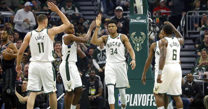 Milwaukee Bucks' Giannis Antetokounmpo gives high-fives to his teammates during the first half of Game 2 of an NBA basketball first-round playoff series against the Detroit Pistons on Wednesday, April 17, 2019, in Milwaukee. (AP Photo/Aaron Gash)