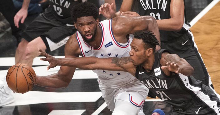 Philadelphia 76ers center Joel Embiid passes the ball around Brooklyn Nets guard Treveon Graham (21) during the second half of Game 4 of a first-round NBA basketball playoff series, Saturday, April 20, 2019, in New York. (AP Photo/Mary Altaffer)