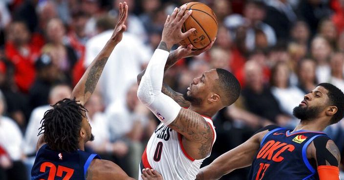 Portland Trail Blazers guard Damian Lillard, center, shoots between Oklahoma City Thunder guard Terrance Ferguson, left, and forward Paul George, right, during the second half of Game 5 of an NBA basketball first-round playoff series, Tuesday, April 23, 2019, in Portland, Ore. The Trail Blazers won 118-115. (AP Photo/Craig Mitchelldyer)