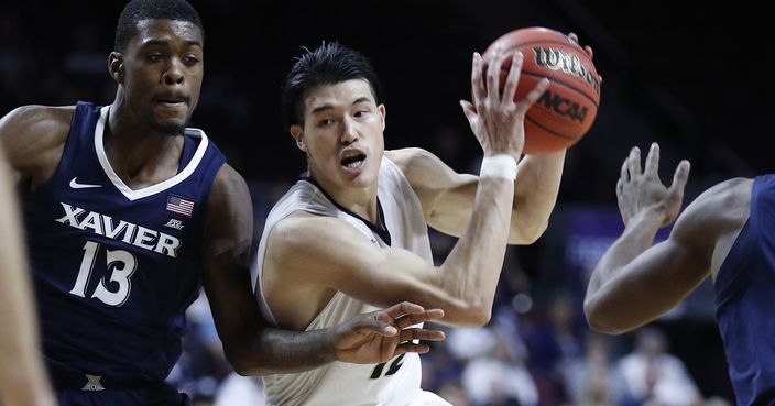 George Washington's Yuta Watanabe drives around Xavier's Naji Marshall (13) during the second half of an NCAA college basketball game Thursday, Nov. 23, 2017, in Las Vegas. Xavier won 83-64. (AP Photo/John Locher)