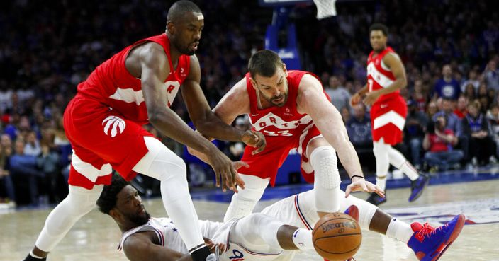 Philadelphia 76ers' Joel Embiid, bottom, and Toronto Raptors' Serge Ibaka, left, and Marc Gasol struggle for a loose ball during the second half of Game 6 of a second-round NBA basketball playoff series Thursday, May 9, 2019, in Philadelphia. (AP Photo/Chris Szagola)