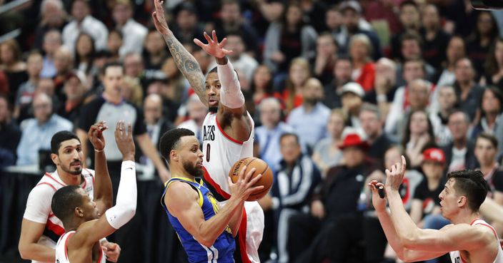 Golden State Warriors guard Stephen Curry, center, is defended by Portland Trail Blazers guard Damian Lillard (0) during the second half of Game 3 of the NBA basketball playoffs Western Conference finals, Saturday, May 18, 2019, in Portland, Ore. The Warriors won 110-99. (AP Photo/Ted S. Warren)