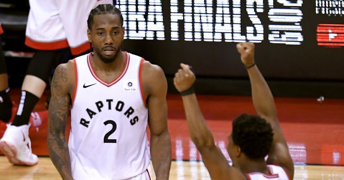 Toronto Raptors' Kawhi Leonard (2) and Kyle Lowry (7) react during the second half of Game 6 of the team's NBA basketball playoffs Eastern Conference finals against the Milwaukee Bucks on Saturday, May 25, 2019, in Toronto. The Raptors won 100-94 to advance to the NBA Finals. (Frank Gunn/The Canadian Press via AP)