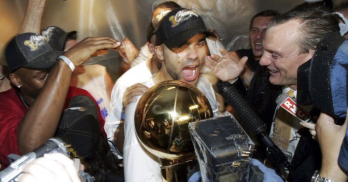 FILE - In this June 23, 2005, file photo, San Antonio Spurs' Tony Parker celebrates with the NBA Trophy in the locker room after the Spurs defeated the Detroit Pistons 81-74 in Game 7 of the NBA finals in San Antonio.  Four-time NBA champion Tony Parker has announced he's retiring after 18 seasons. The 37-year-old guard played 17 said on Twitter Monday, June 10, 2019, that it was an emotional decision and that it has been an 