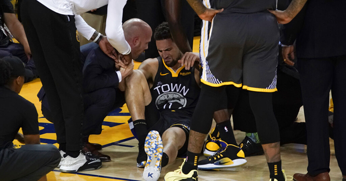 Golden State Warriors guard Klay Thompson, center, is helped up after being injured during the second half of Game 6 of basketball's NBA Finals against the Toronto Raptors in Oakland, Calif., Thursday, June 13, 2019. (AP Photo/Tony Avelar)