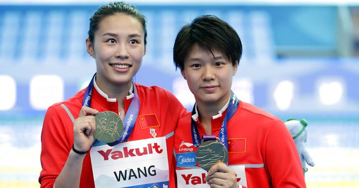 Wang Han, left, and Shi Tingmao of China hold their gold medals after competing in the finals of the women's 3 meter springboard synchronized diving competition at the World Swimming Championships in Gwangju, South Korea, Monday, July 15, 2019. (AP Photo/Mark Schiefelbein)