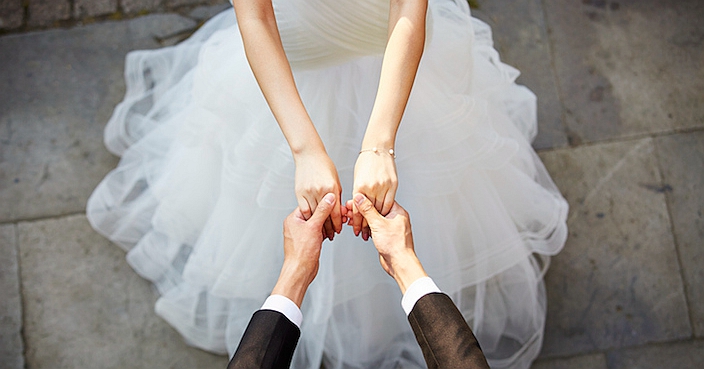 young asian bride and groom holding hands and dancing, high angle view.