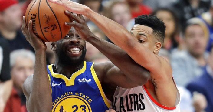 Portland Trail Blazers guard CJ McCollum, (3) defends against Golden State Warriors forward Draymond Green (23) during the first half of Game 3 of the NBA basketball playoffs Western Conference finals, Saturday, May 18, 2019, in Portland, Ore. (AP Photo/Ted S. Warren)