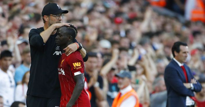 Liverpool's manager Jurgen Klopp, left, hugs Liverpool's Sadio Mane during the English Premier League soccer match between Liverpool and Arsenal at Anfield stadium in Liverpool, England, Saturday, Aug. 24, 2019. (AP Photo/Rui Vieira)